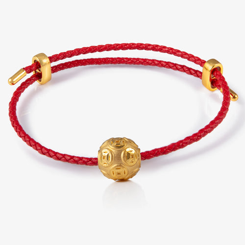 24K gold spherical charm with ancient coin engravings

金色球形串饰，雕刻古钱图案

Prosperity charm shaped like a moneyball

聚财金球金饰，寓意多方财富聚集