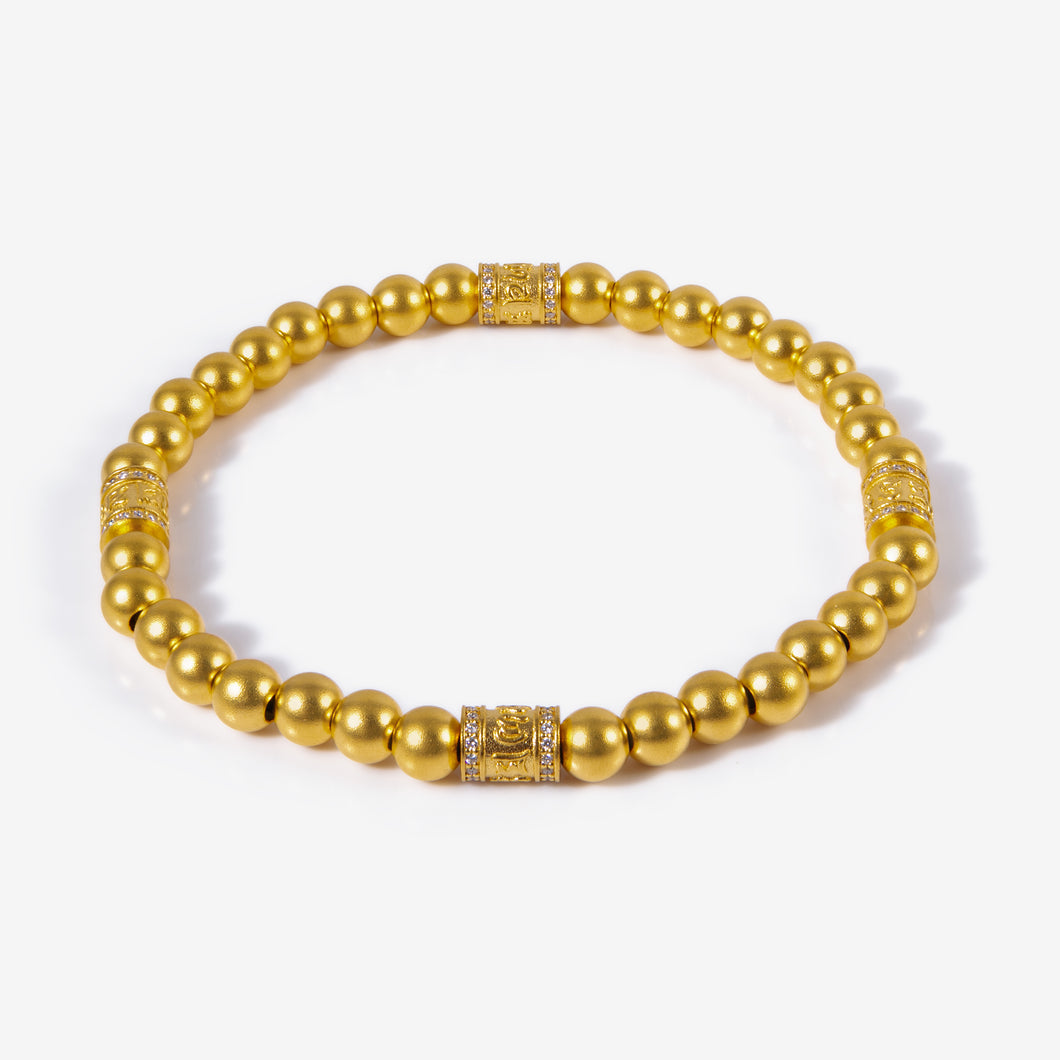 24K gold six-syllable bead bracelet with matte finish and diamond-set charms

Close-up of diamond-set Dharma charm on antique gold bead bracelet