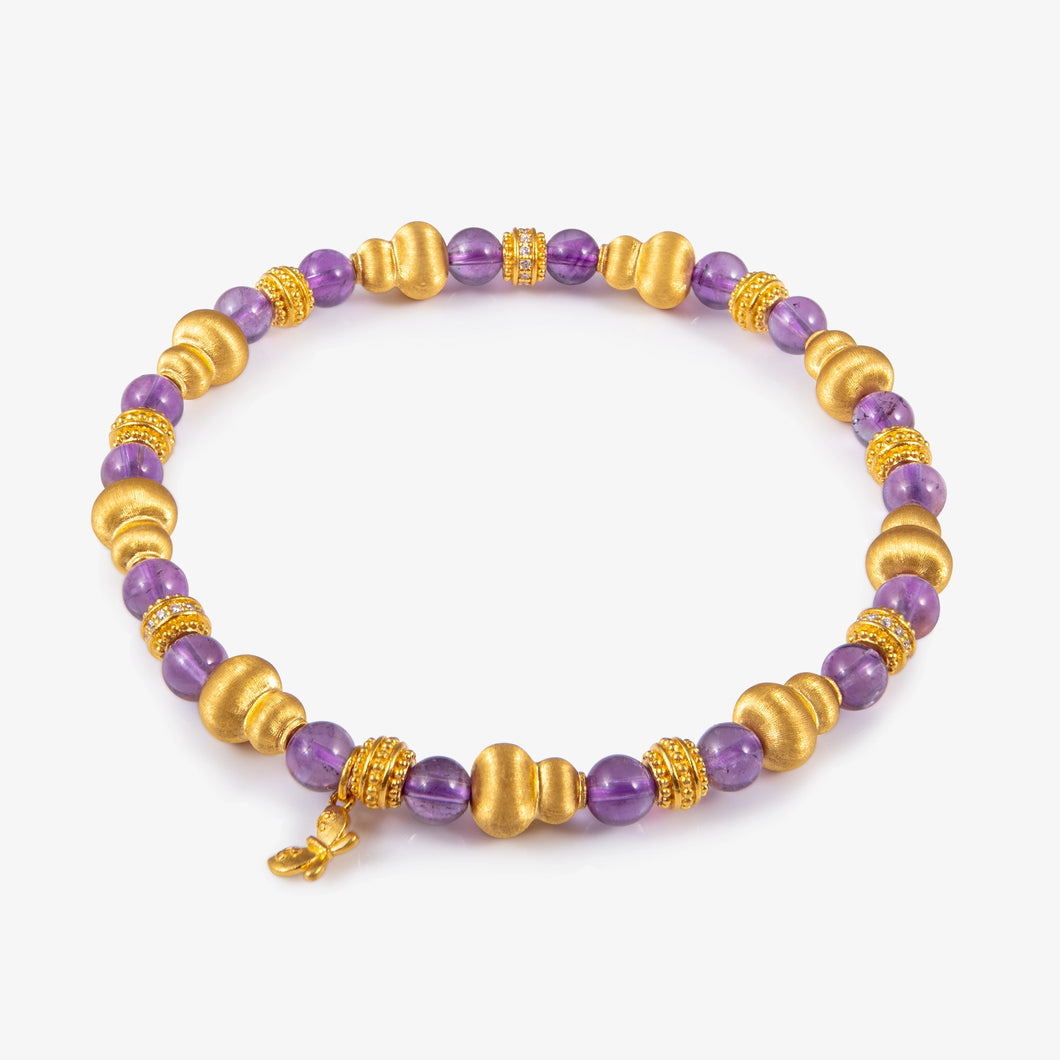 Bracelet with purple and gold beads on a white background