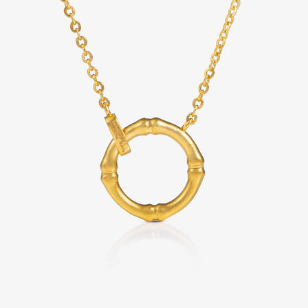 Gold necklace with a bamboo pendant on a white background